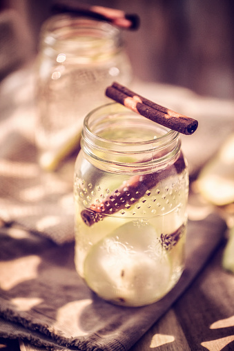 Infused water with fresh pears and cinnamon served in a glass jar.