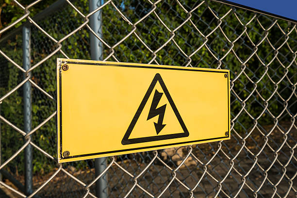 istock High Voltage warning sign on wires fence net 623611738