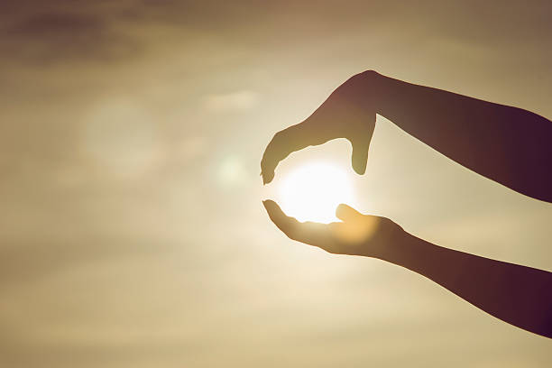 istock two hands to holding a sun on sunset moment,hoping 623612268