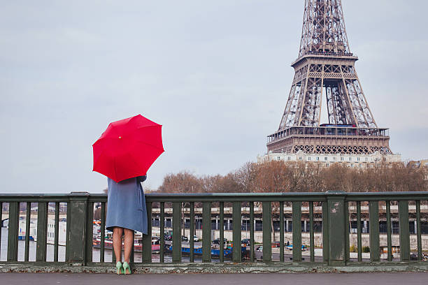 istock woman with red umbrella in Paris 623614178