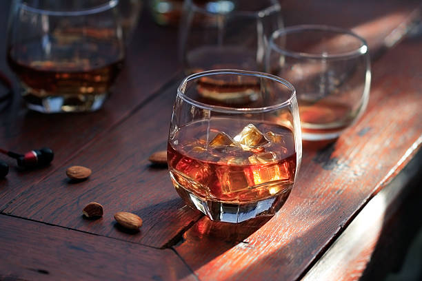 istock Whiskey bourbon in glass with ice on wooden table background 623615228