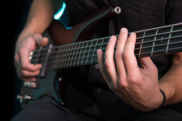 istock Young man playing electric guitar on dark background 623617016