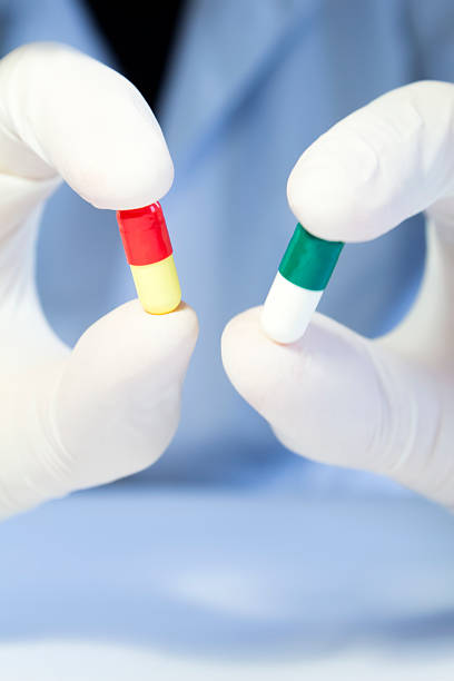 istock Close-up hand in medical rubber glove holding two different capsules 623619496