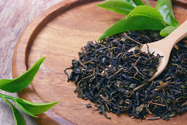 istock green tea leaf on wooden spoon 623664234