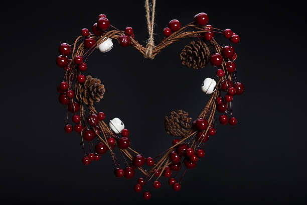 istock Heart shaped Christmas decoration with pine cones on dark background 623664912