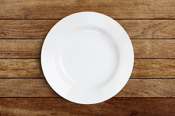istock Simple white circular porcelain plate on wood with clipping path 623667308