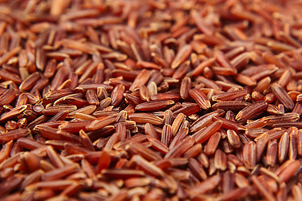 Red rice close-up background. Red rice close-up background. Heap wild brown unpolished rice for vegetarians. genmai stock pictures, royalty-free photos & images