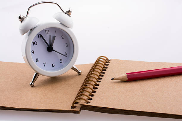 istock Color pencil and an alarm clock placed on a notebook 623684820