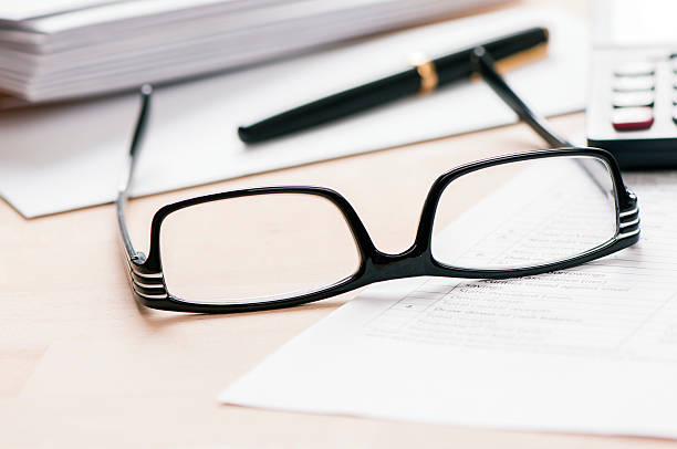 istock Glasses and pen on desk 623685348