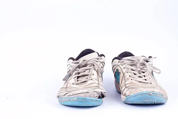 Photo of Old vintage damaged futsal sports shoes  on white background  isolated