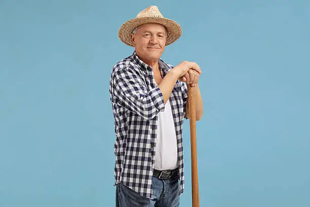 Photo of Mature farmer posing on blue background