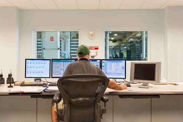 technician at the computers in a control room - water plant fotos imagens e fotografias de stock