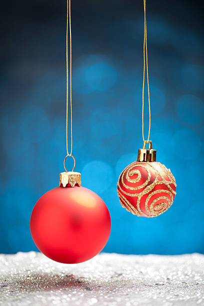 istock Red christmas baubles on silver glitter with blue background 623690738