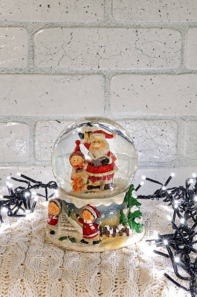 istock Christmas snow globe with santa claus inside and garland lights 623692508