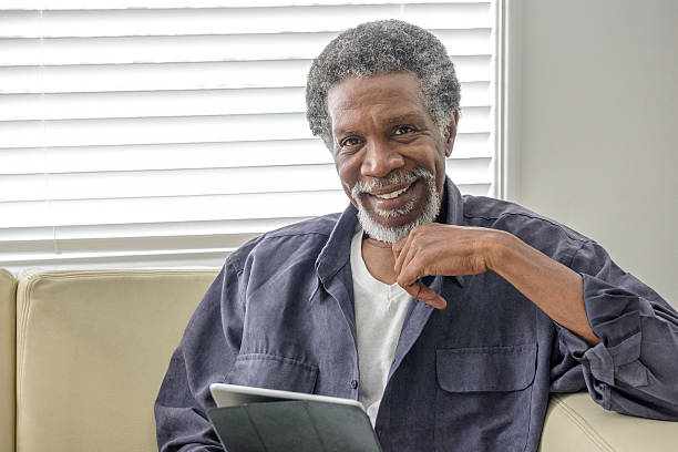istock Cheerful senior African American man using tablet at home 623699576
