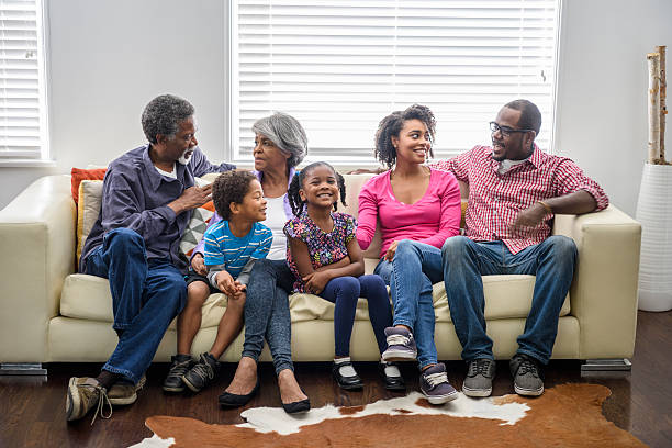 mehrgenerationen-afrika-familie sitzt auf sofa - grandmother senior adult child multi generation family stock-fotos und bilder