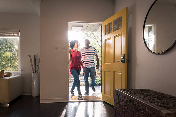 african american couple arriving home in doorway, smiling - open front door imagens e fotografias de stock