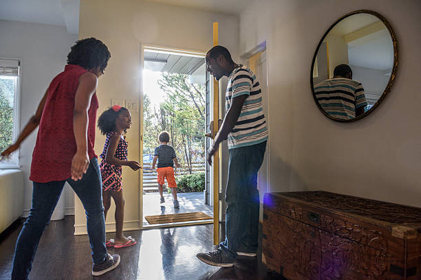 familia afroamericana saliendo de la casa, padre sosteniendo la puerta - home sale fotografías e imágenes de stock