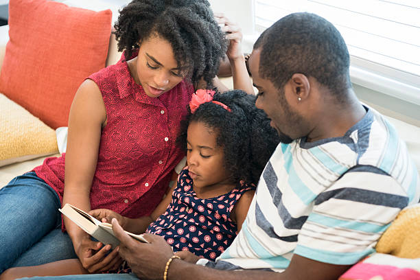 istock African American parents helping daughter read book, high angle 623700860