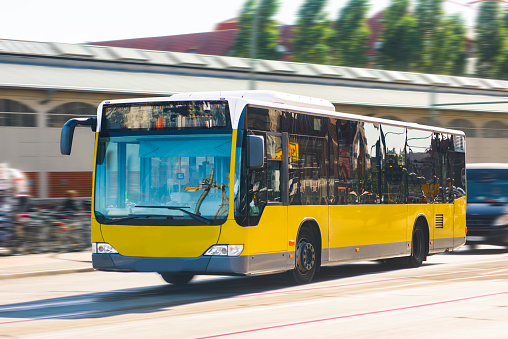 A yellow Berlin bus in motion