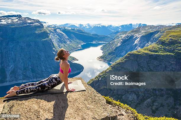 Young Woman Doing Yoga On Trolltunga Happy Girl Enjoy Beautiful Stock Photo - Download Image Now