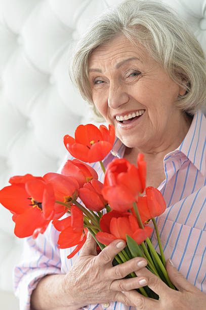 istock Senior woman with blooming poppies 623703658