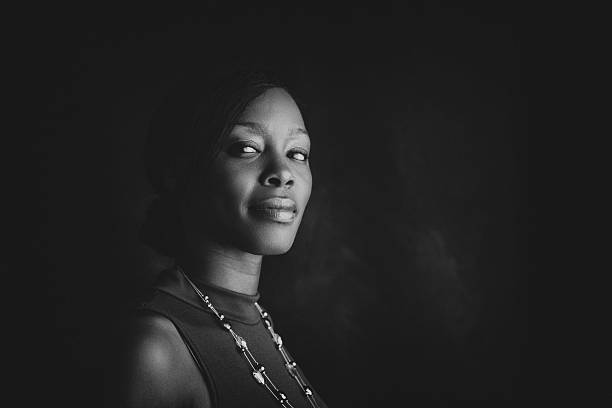 confident portrait of a black woman friendly portrait of a woman looking towards viewer monochrome stock pictures, royalty-free photos & images