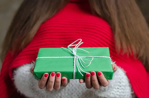 Photo of girl with thick and long hair holding a gift