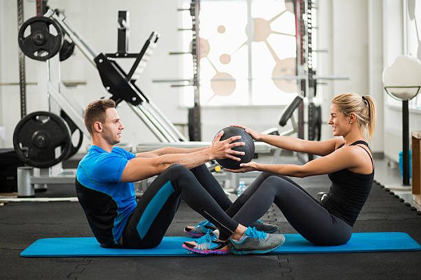 istock Two young sporty people doing sit-ups with medicine ball 623707330