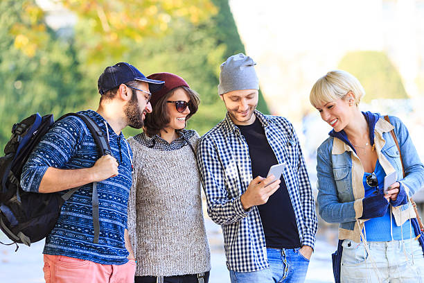 istock Group of tourists using smart phone on street 623708284