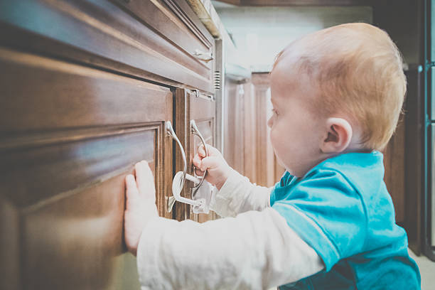 부엌에서 잠긴 캐비닛 핸들을 만지는 아기 소년 - domestic kitchen accessibility open drawer 뉴스 사진 이미지