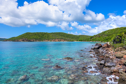 Clear turquoise blue water and rocky shoreline becoming sandy beach in the distance at Punta Soldado Beach on Puerto Rico island of Isla Culebra