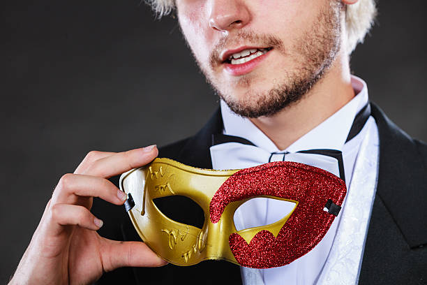 istock Young man in carnival mask on dark 623713698