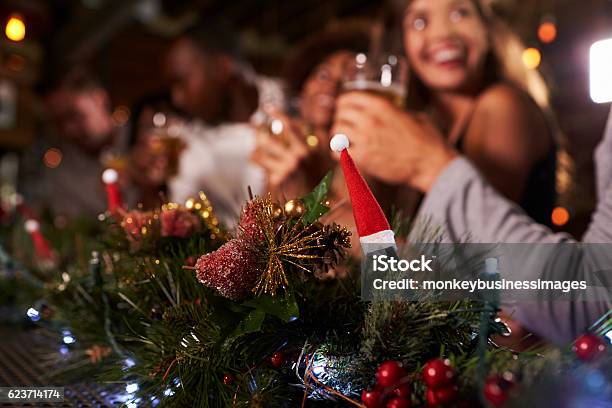 Christmas Party At A Bar Focus On Foreground Decorations Stock Photo - Download Image Now