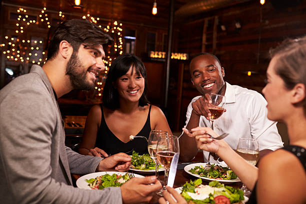 istock Four friends enjoying dinner and drinks at a restaurant 623714342