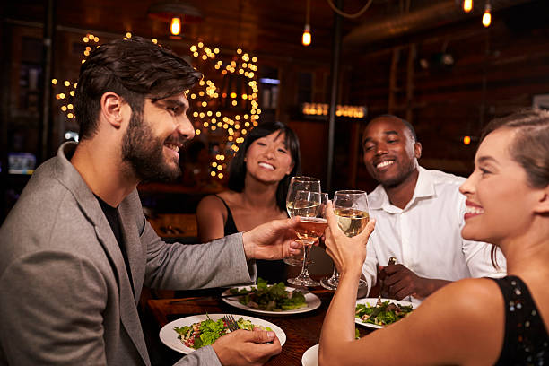 istock Four friends making a toast over dinner at a restaurant 623714438
