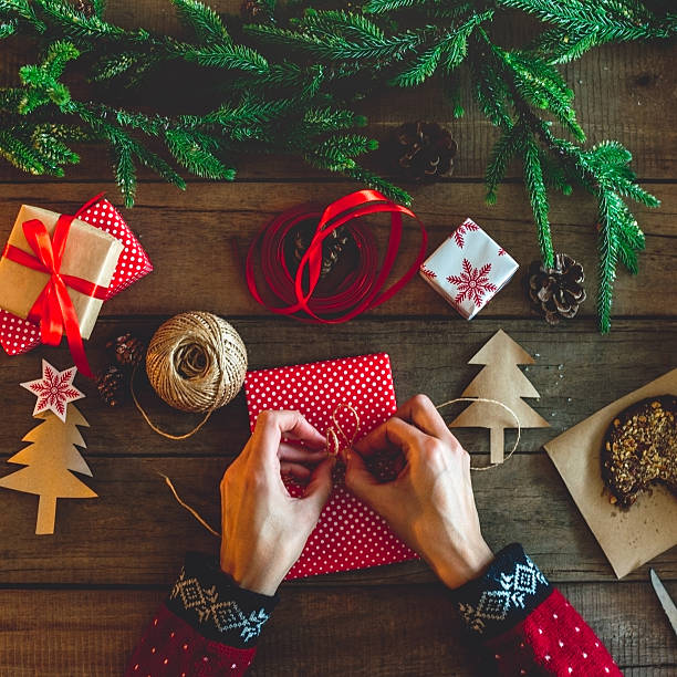 istock Hands wrapping a gift over wooden table 623715290