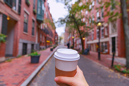 walking around town with coffee in hand. the concept of people traveling. blurred background due to the concept 