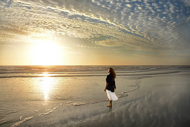 istock Woman enjoying time on the beach at sunrise. 623745314