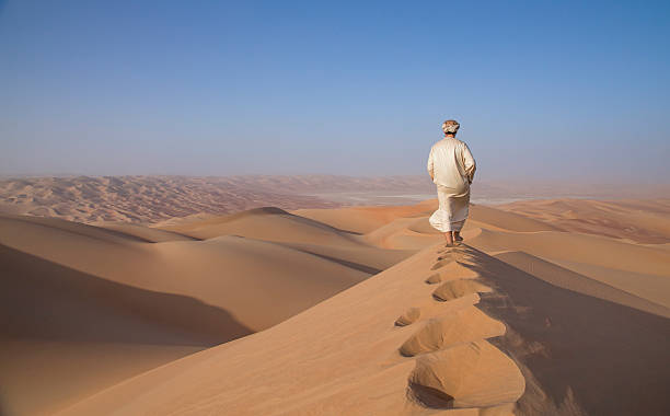 homem em kandura em um deserto ao nascer do sol - dry country - fotografias e filmes do acervo