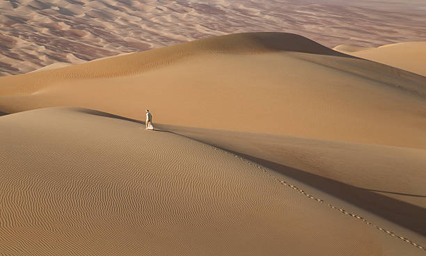 istock Man in kandura in a desert at sunrise 623748998