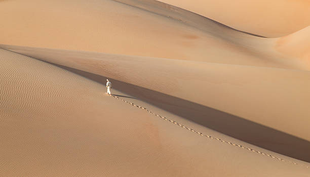 istock Man in kandura in a desert at sunrise 623749002