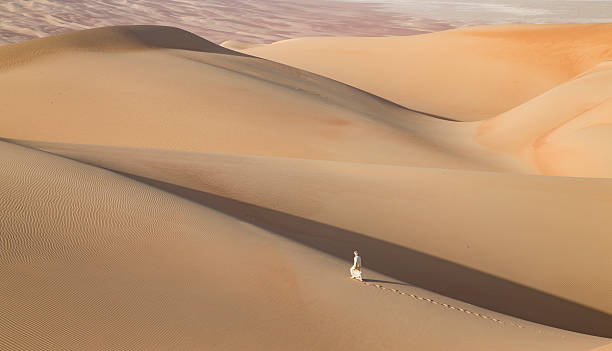 istock Man in kandura in a desert at sunrise 623749028