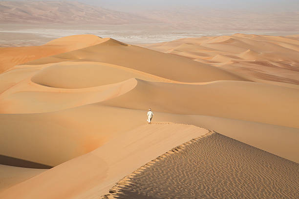 istock Man in kandura in a desert at sunrise 623749040