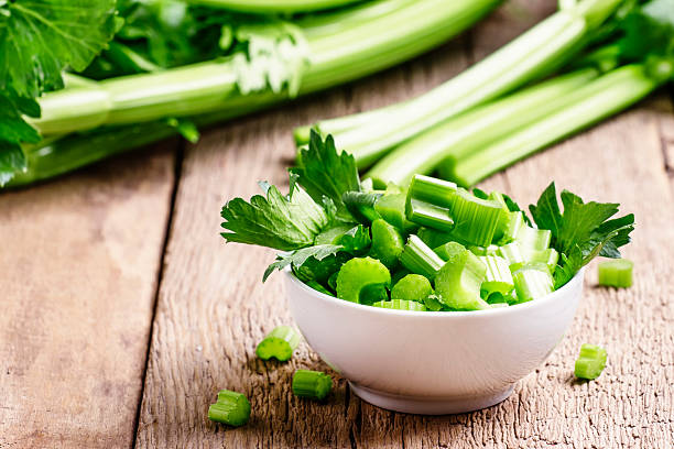 Fresh sliced celery in a white bowl Fresh sliced celery in a white bowl on a vintage wooden background, selective focus stick plant part photos stock pictures, royalty-free photos & images
