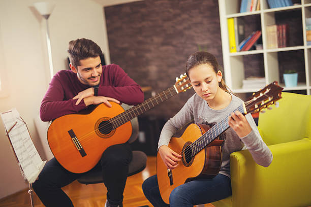istock Guitar teacher teaching the little girl 623752424