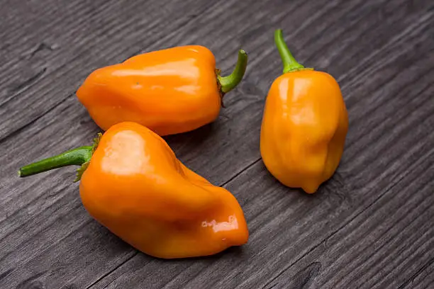 Photo of some vegetable of orange chili pepper habanero on wooden vintage