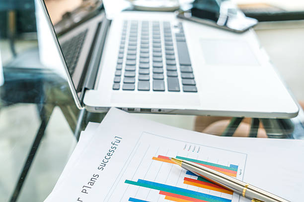 istock Laptop and financial charts on a table 623760312