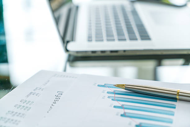 istock Laptop and financial charts on a table 623760524