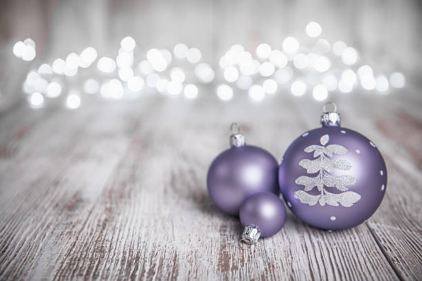 Purple Christmas Ornaments on Old white Wood Background and defocused lights